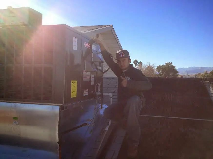 HVAC technician performing AC Tune-Up on a rooftop unit in Vidor